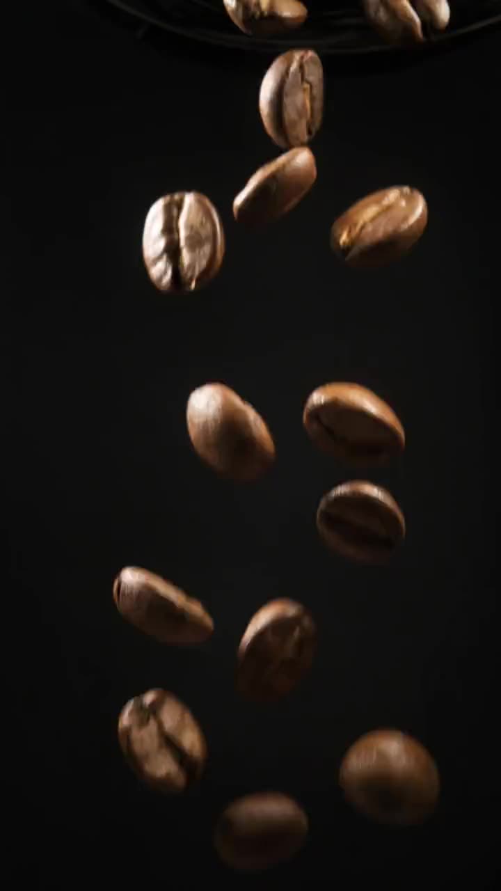 Dark-roast beans tumbling (licensed stock, generic)
