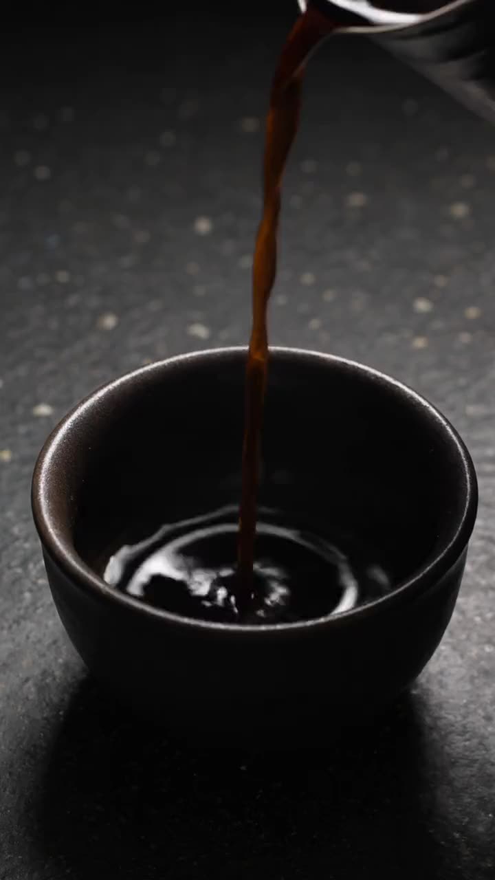 Overhead pour into a dark cup (licensed stock, generic)
